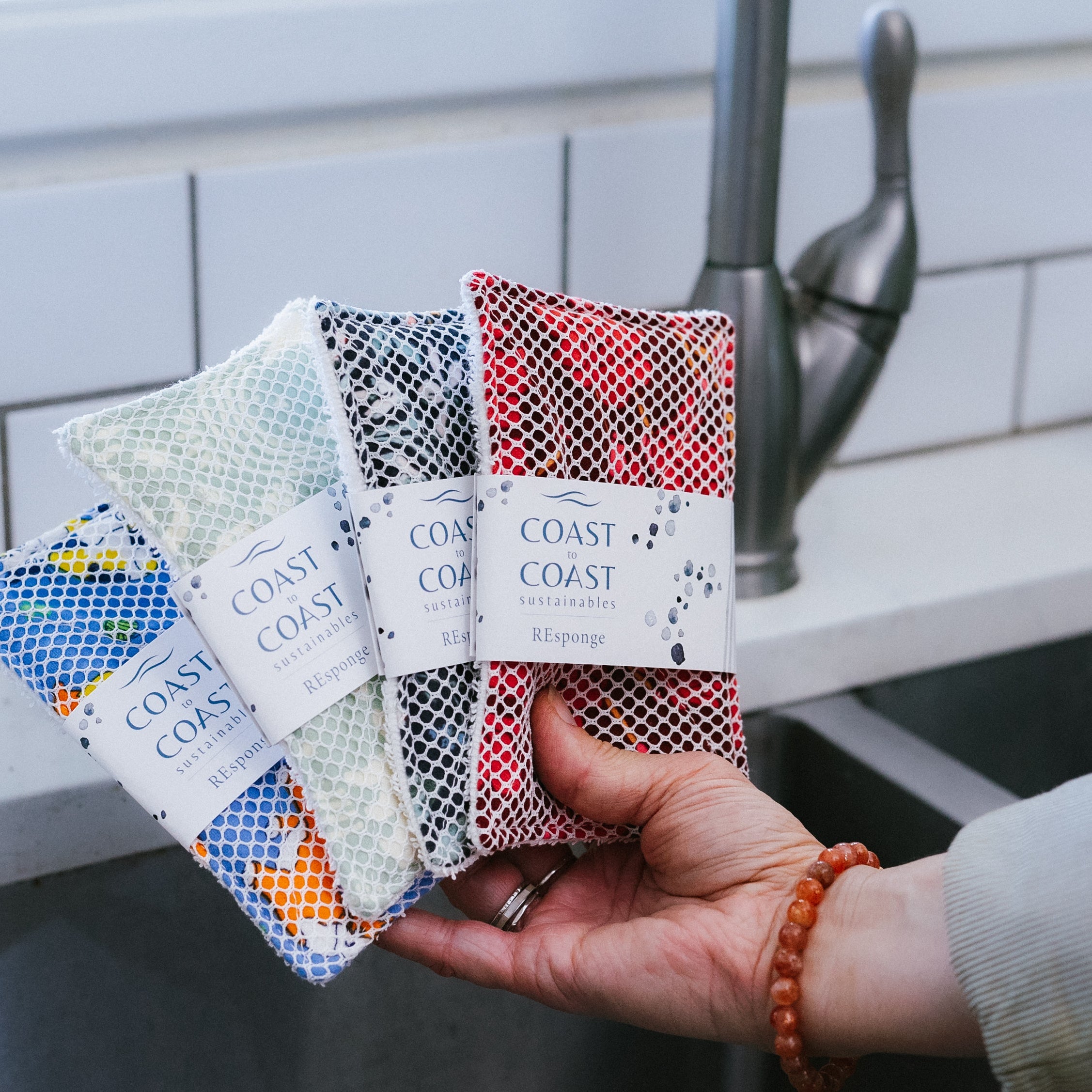 REsponges in variety of colors over kitchen sink