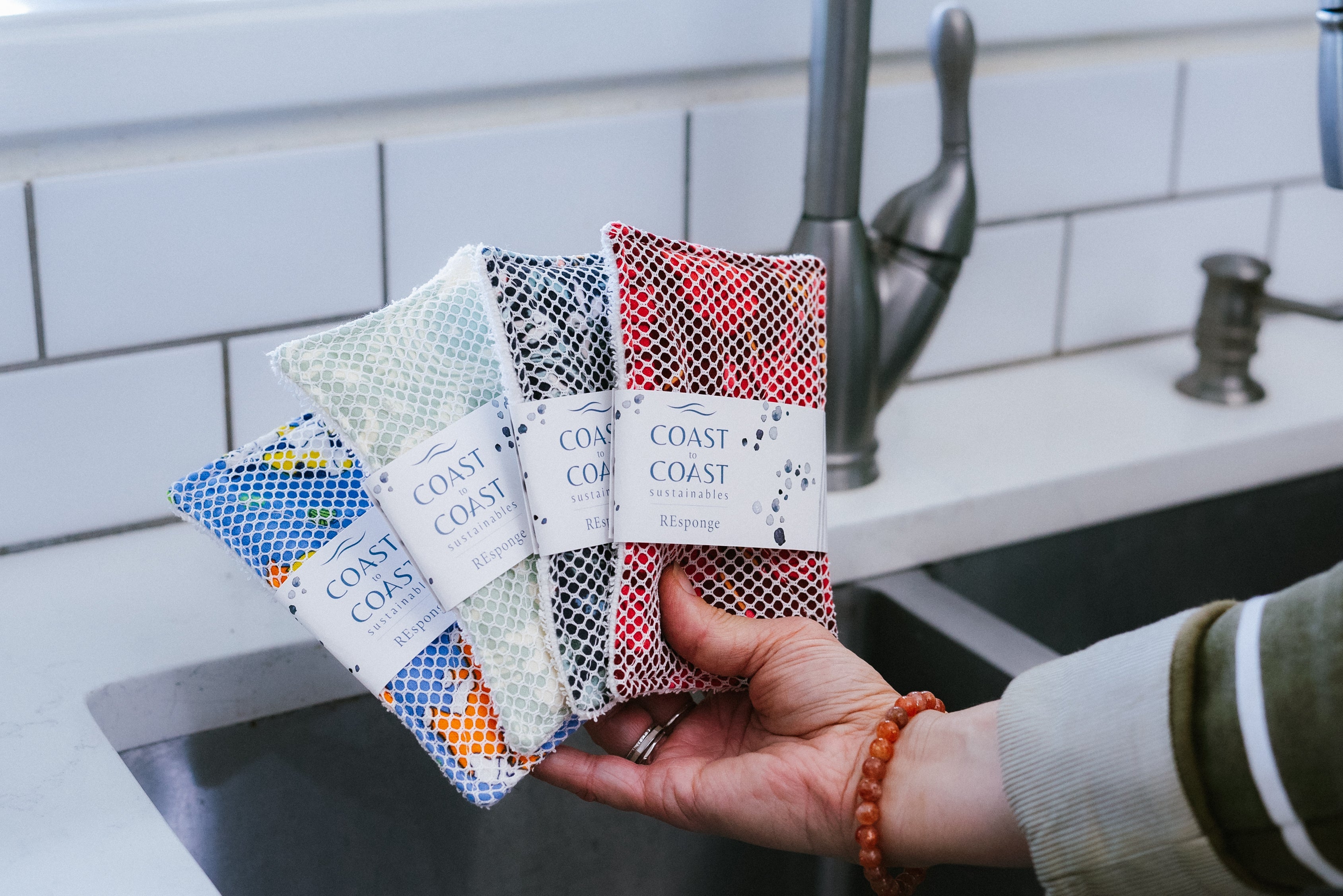 REsponges in variety of colors over kitchen sink